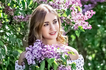 Portrait of a smiling young girl in blooming lilac trees. Summer time,vacation