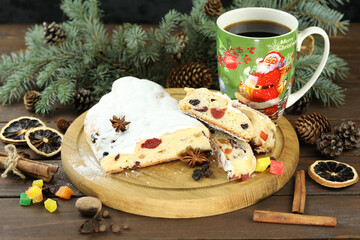 traditional stollen with decoration and cup of coffee on wooden background