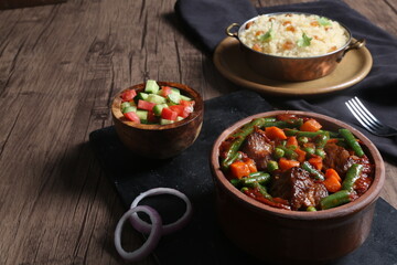 vegetable casserole with meat served with fresh salad on a black tray