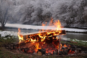 Fireplace with firs against winter landscape with snow. Selected focus.