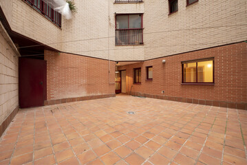Empty inner courtyard of a building with clay terrazzo flooring with ropes for hanging clothes