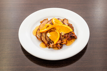 typical recipe of Chinese restaurant in Europe based on roast duck with oranges on a white plate