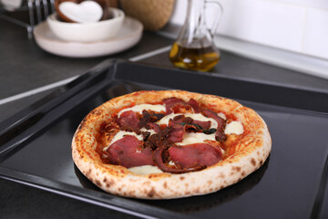 Pizza with beef on the kitchen table