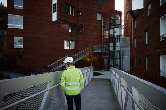 Construction worker standing on bridge in residential area