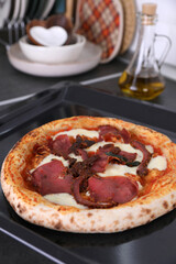 Pizza with beef on the kitchen table
