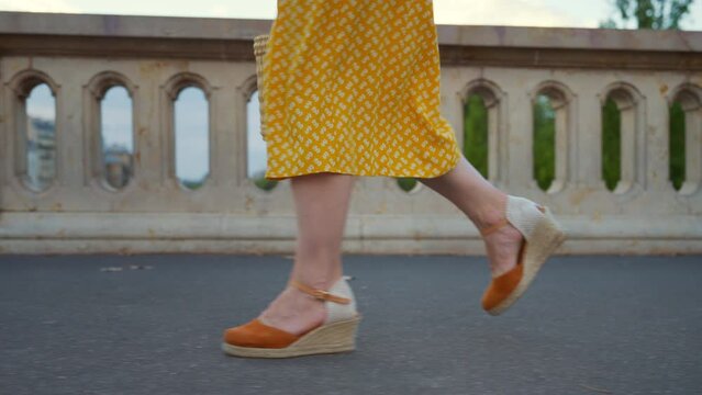 Attractive girl in a yellow skirt walking along the Seine embankment