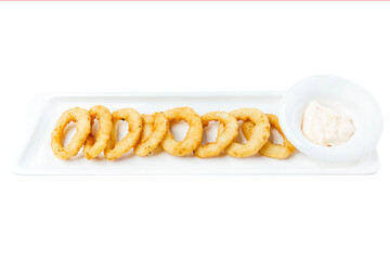 Fried squid rings in batter with sauce. Appetizing popular snack for beer. Close-up. Top view. Isolated on white background.
