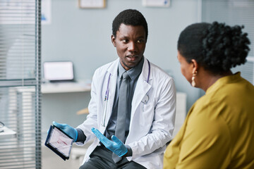 Young medical professional talking to patient in clinic