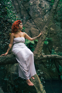 Chica guapa con vestido blanco en un bosque verde frondoso encantado hippie