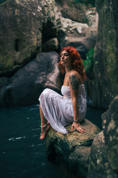 Chica guapa con vestido blanco en un bosque verde frondoso encantado hippie