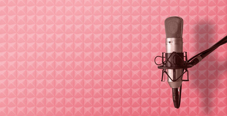Pink acoustic foam background with studio vocal microphone. Podcast or radio broadcast banner with...