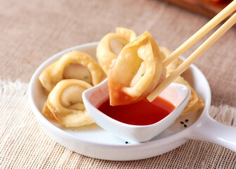 Dim sum with chopsticks and red sauce