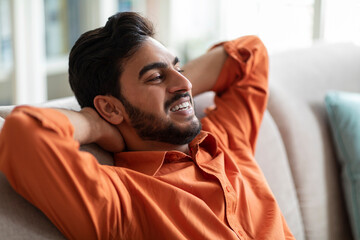 Fototapeta premium Closeup of relaxed middle eastern guy chilling at home