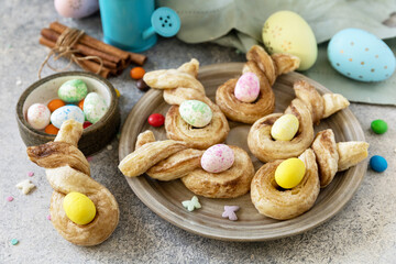 Easter bake idea. Easter rabbit-shaped buns puff pastry with  cinnamon on a stone tabletop.