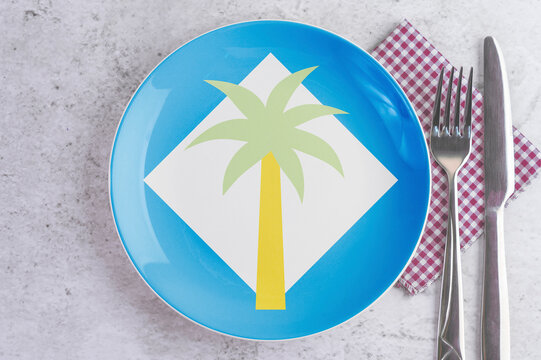 A Plate with the Flag of Clipperton Island, Cutlery and Napkins on the Mable Table.