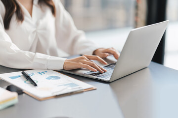 Young beautiful businesswoman working with her laptop computer in office room.