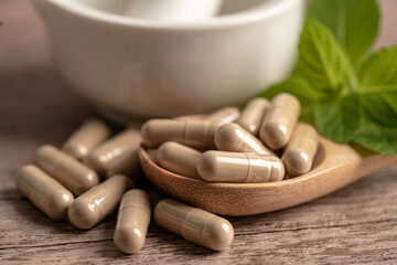 Fototapeta na wymiar Alternative medicine herbal organic capsule drug with herbs leaf natural supplements for healthy good life.
