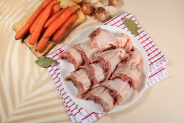 Fresh chicken skeletons and vegetables, carrots and onions. Raw chicken backs skin on bone