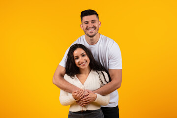 Happy family relationships. Cheerful young arab guy hugging female, enjoy tender moment, have fun