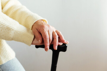 Closeup of old woman hands on canes. Elderly loneliness. Elderly care. Concept of health caring for elderly old people, disabled.