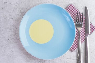 A Plate with the Flag of Palau, Cutlery and Napkins on the Mable Table.