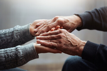 Closeup of hands of old man and a young female hands. Senior man, with caregiver indoors. Concept of health caring for elderly old people, disabled.