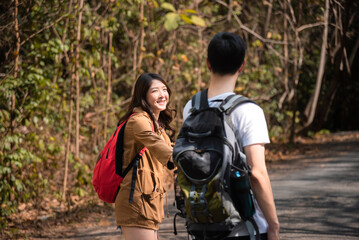 Asian smart male and beautiful female trekking and hiker in holiday together, Active young tourists relaxing in holiday, couple traveling summer adventure journey in nature outdoors.