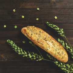 Baguette with cheese, garlic and herbs. French and Mediterranean cuisine. Fresh pastries on wooden...