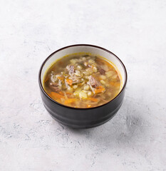 Traditional Russian soup with pickled cucumbers. Pickle with pearl barley and meat on a light background. Healthy and homemade food.