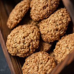 Homemade oatmeal cookies. Fresh pastries in bakery. Healthy sweets made from whole grain flour. Dessert in wooden box. Close-up. Soft focus. View from above.