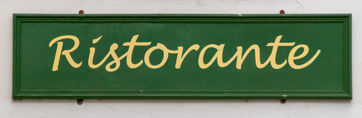 A hand-painted wooden sign for an Italian restaurant/ristorante