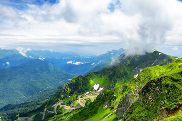 Amazing mountain landscape on sunny summer day with a rainbow in the sky.