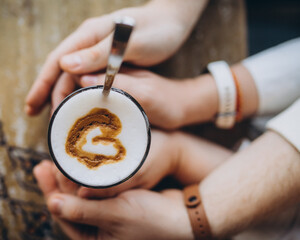 Fototapeta na wymiar hands holding coffee cup with love sign