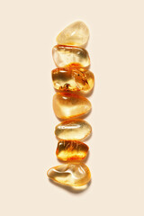 Aesthetic minimal pattern, set of amber stones gradient color on beige background. Line composition from natural gemstones. Summer concept of harmony, spa. Top view, flat lay. Still life