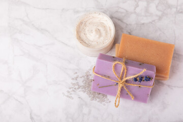 Fototapeta na wymiar Lavender spa. Cosmetic products sea salt, body cream, scrub, essential oils and lavender flowers on a marble background.Natural herb cosmetic with lavender flowers. Beauty concept. Copy space.