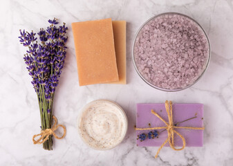 Fototapeta na wymiar Lavender spa. Cosmetic products sea salt, body cream, scrub, essential oils and lavender flowers on a marble background.Natural herb cosmetic with lavender flowers. Beauty concept. Copy space.