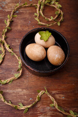 Black bowl with brown colored Easter eggs on rustic background. Spring, Easter concept. vertical shot