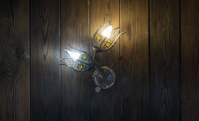 chandelier in the shape of a flower on a wooden wall