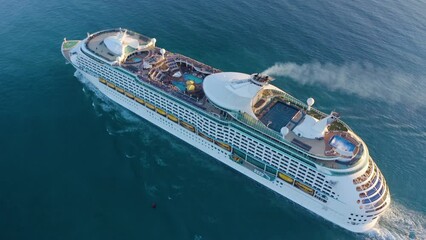 Cruise ship sailing across The Mediterranean sea - Aerial footage. Aerial view of a beautiful white cruise liner in a sunny day. Luxury cruise in the ocean sea concept tourism travel.  - Powered by Adobe