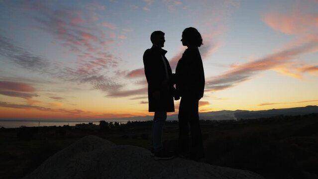 Couple hug together on the mountains in silhouette