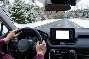 man driving a car on an winter road. back view. Close-up of hands on a steering wheel. view from...