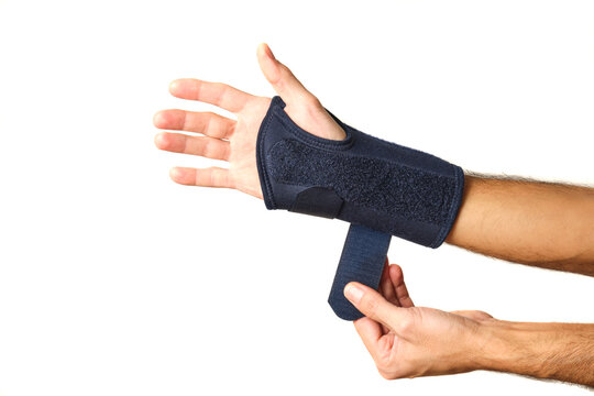 man's hands putting on a therapeutic wrist brace to relieve the pain of a sprain