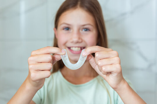 Teenager girl wear simulator orthodontic silicone invisible leveling braces for teeth. Dental concept, orthodontics