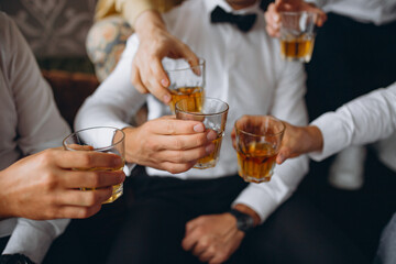 Business meeting. Men hold glasses of whiskey. Men's Party. Hand with a drink of alcohol.