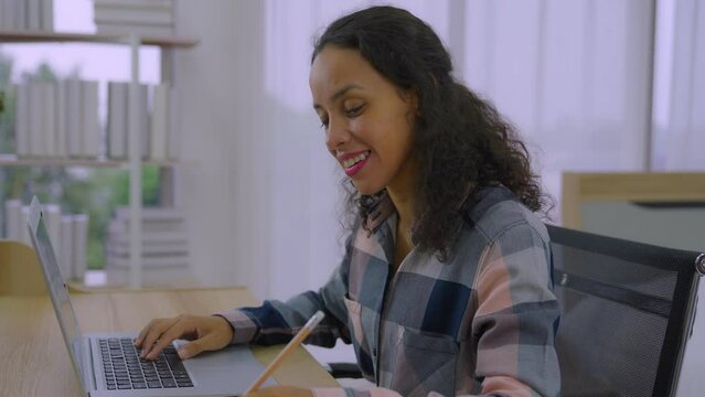Young black mixed race woman study on distance take notes of online trainer teacher coach lecture course in web app. American lady online webinar client engaged in remote learning.