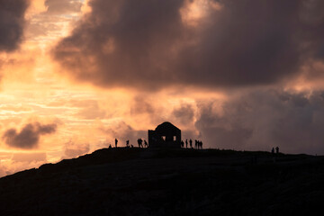 Silhouette of people and a ruin at sunset