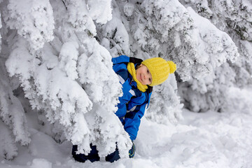 Sweet happy child, playing in deep snow