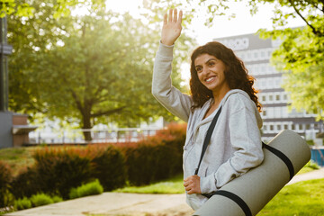 Young woman gesturing while standing after yoga practice in park