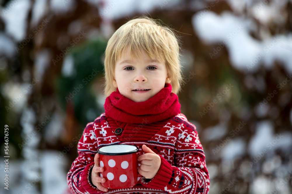 Sticker Sweet blond toddler child, boy, playing in garden with snow, making snowman, happy kid winter time