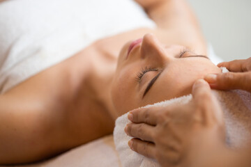 Fototapeta na wymiar happy beautiful caucasian woman enjoying head massage at the spa and wellness center